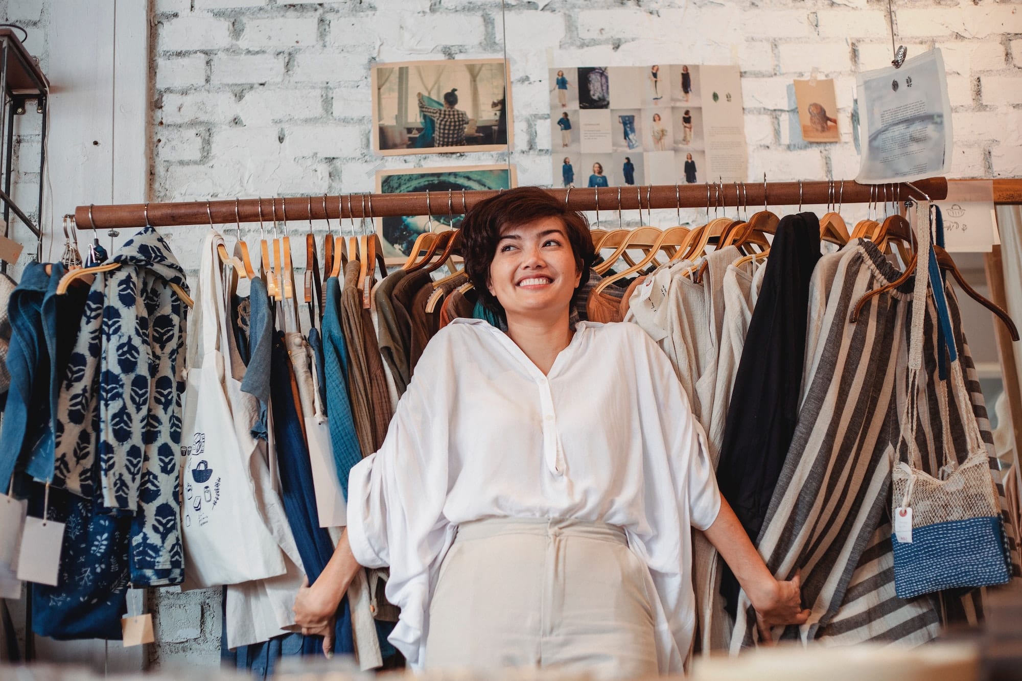 Happy woman standing in front of clothes