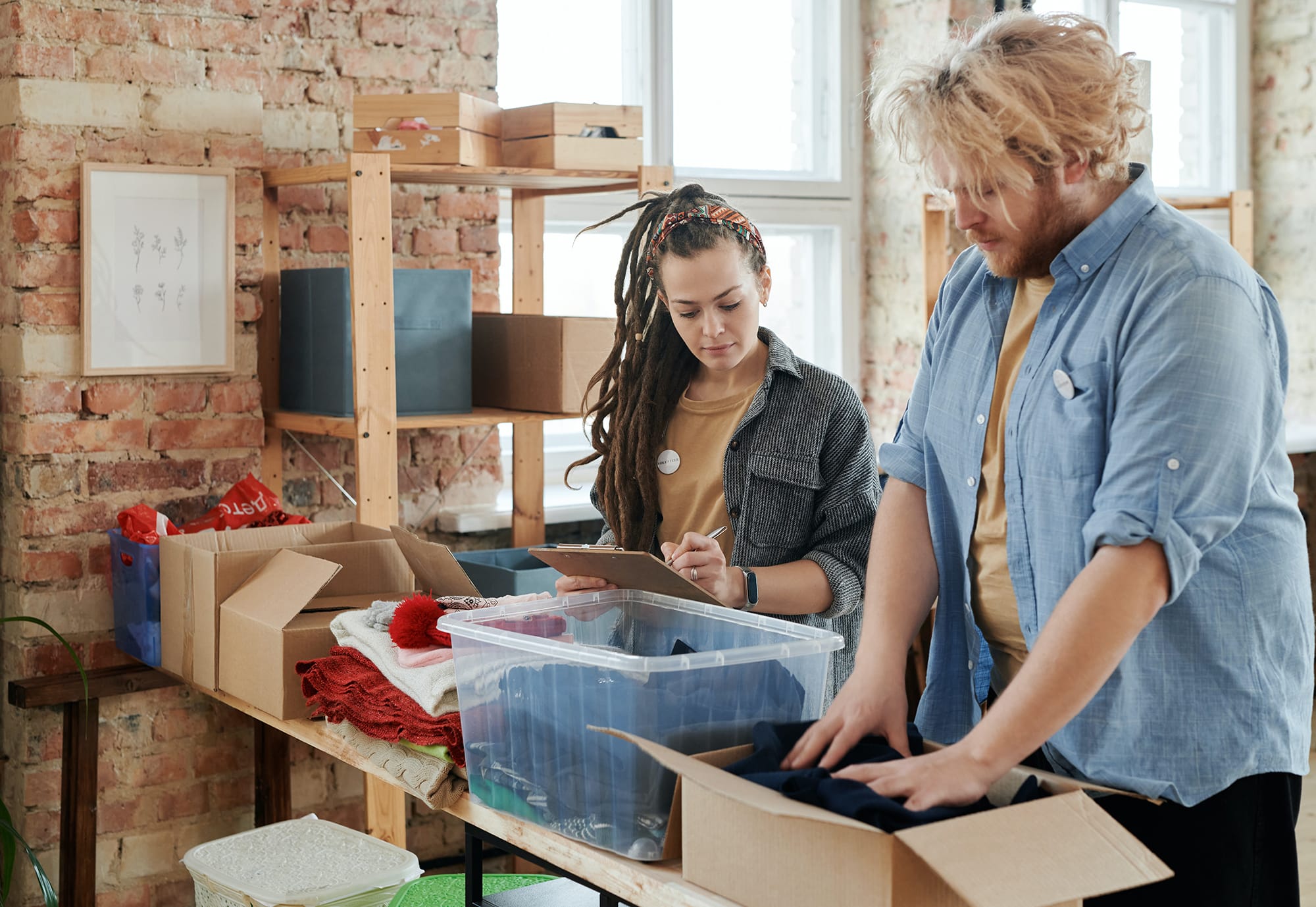 man packing clothing into boxes